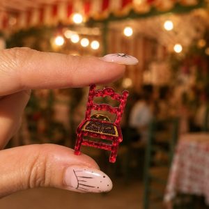 Pin de solapa para hombre con forma de silla de feria roja en metacrilato espejo.